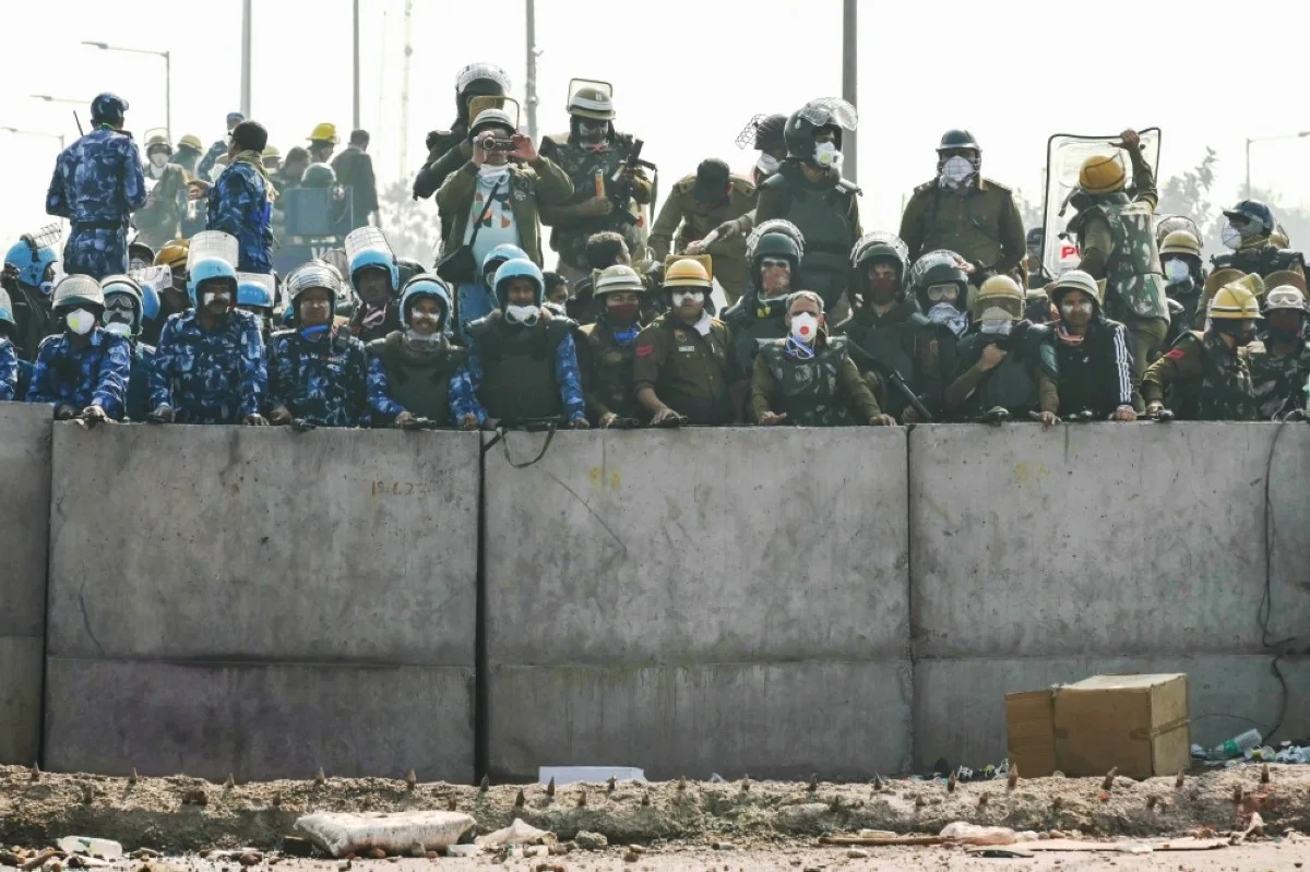 AMBALA, India: Police and Rapid Action Force (RAF) personnel block a highway to prevent farmers from marching towards New Delhi. --AFP
