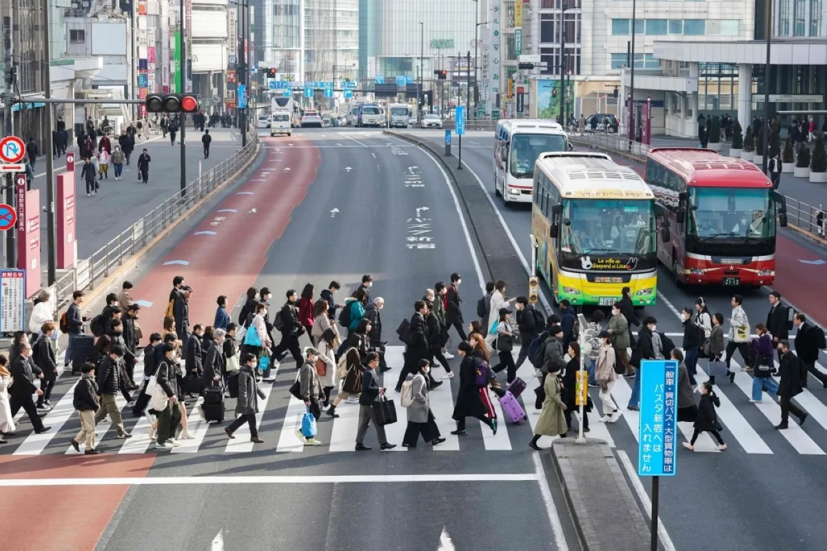 TOKYO: People commuting to work in the morning cross a pedestrian crossing in Tokyo on February 15, 2024. – AFP
