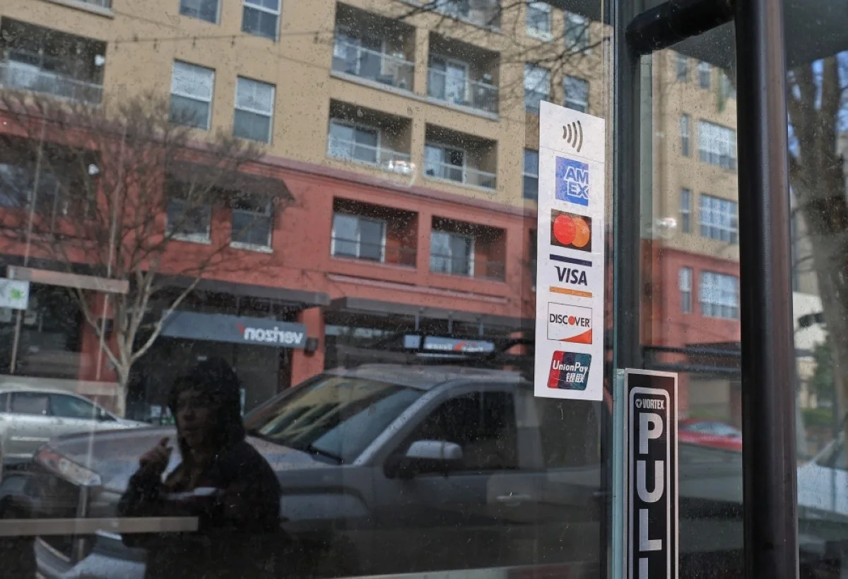 CALIFORNIA: A credit card decal is displayed on the window of a business in San Rafael, California. According to a report by the Federal Reserve Bank of New York, credit card debt in the United States has reached $1.13 trillion. – AFP