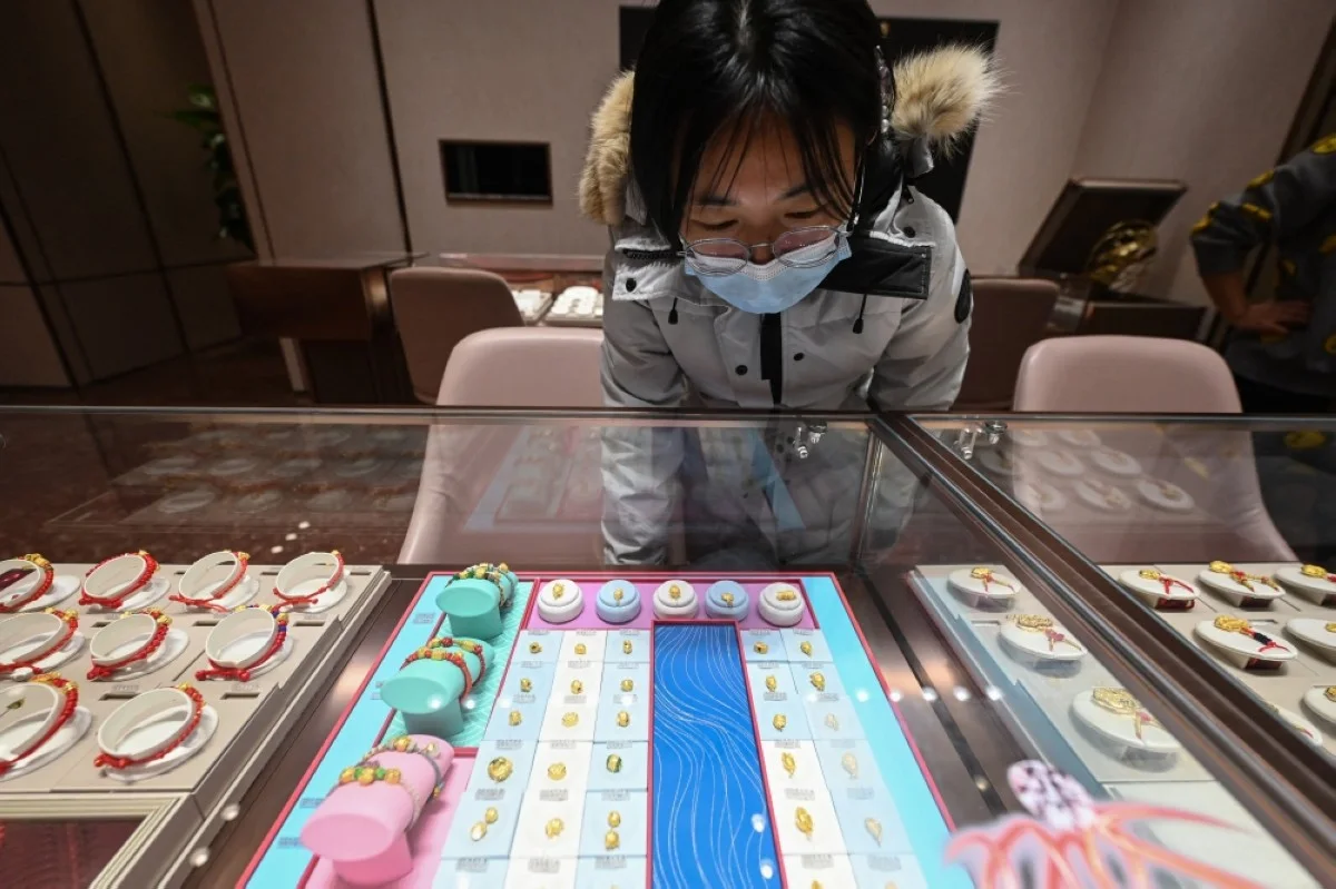 BEIJING: This photo taken on Feb 5, 2024 shows a customer browsing gold jewelry on display at a Chow Tai Fook store in Beijing. -- AFP