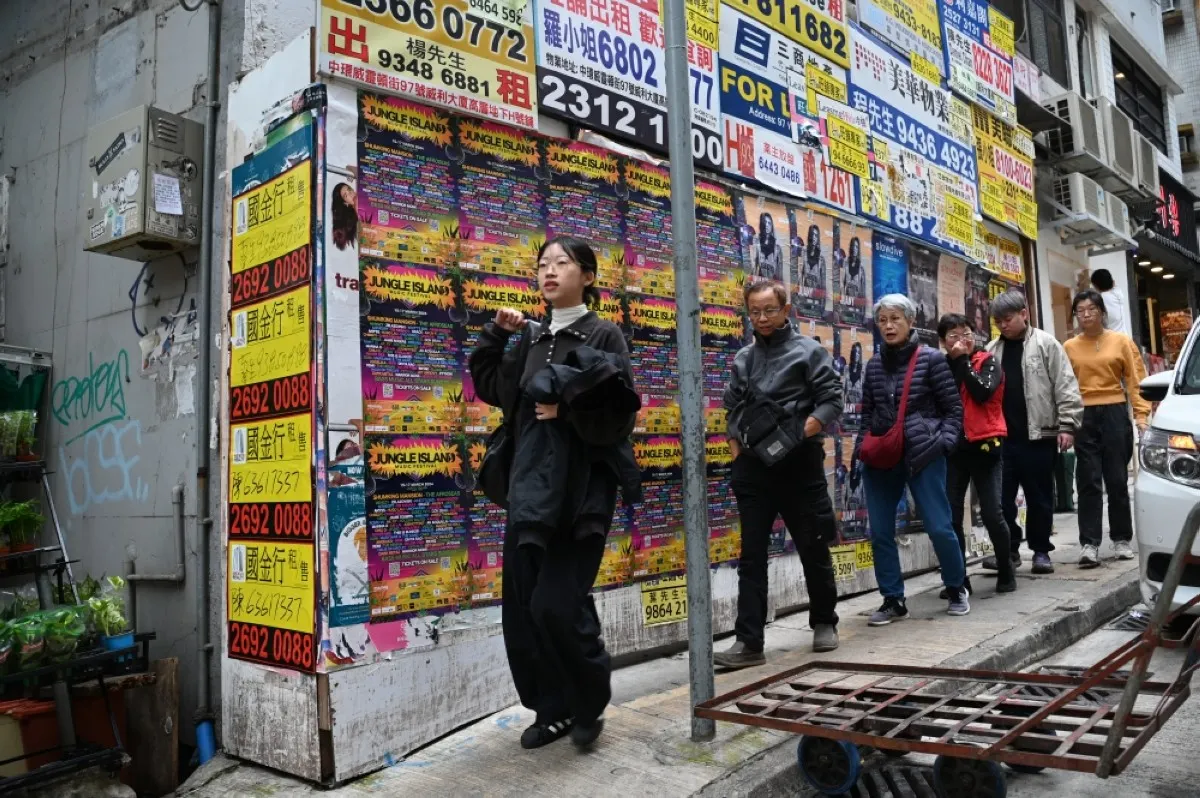 HONG KONG: Pedestrians walk past an empty commercial property in Hong Kong on Feb 28, 2024. Hong Kong has dropped all property market curbs in a bid to boost buyer sentiment, the city's finance chief Paul Chan said in his annual budget speech on Feb 28. – AFP