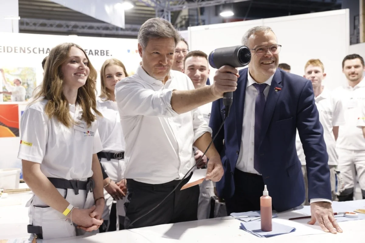 MUNICH: German Minister of Economics and Climate Protection Robert Habeck holds a dryer as a weapon at the booth "Makers wanted!" (Macher gesucht!), the young talent campaign of the Bavarian Craft Day at the "International Craft Fair 2024" (IHM) in Munich, southern Germany. – AFP