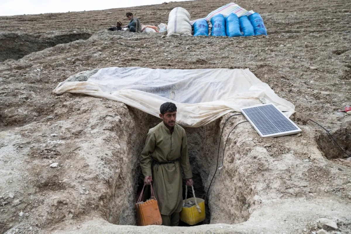 YAFTAL SUFLA, Afghanistan: In this photograph taken on February 24, 2024, an Afghan man carries containers filled with stones and soil from a tunnel at a gold mine in the mountains of Yaftal Sufla district in Badakhshan province. -- AFP