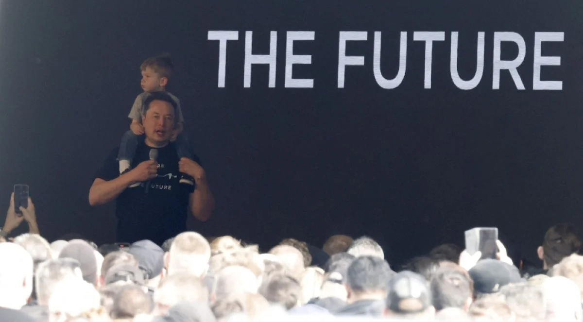 GRUNHEIDE, Germany: Tesla CEO Elon Musk carries on his shoulders his son X Æ A-XII as he addresses employees during a visit at the company's electric car plant in Gruenheide near Berlin, eastern Germany, on March 13, 2024. – AFP