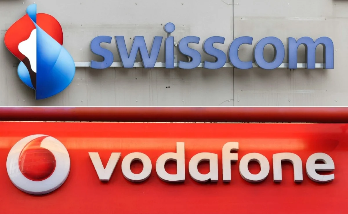 ZURICH: This combination of file photographs shows the logo of Swisscom (top) the logo of Vodafone.—AFP