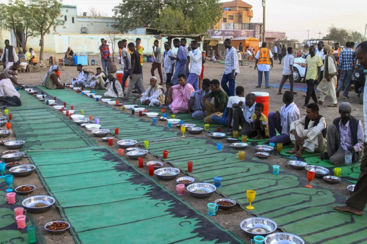 GEDAREF, Sudan: Internally displaced Muslim devotees wait to break their fast at a courtyard during the Islamic holy month of Ramadan in Gedaref.-- AFP