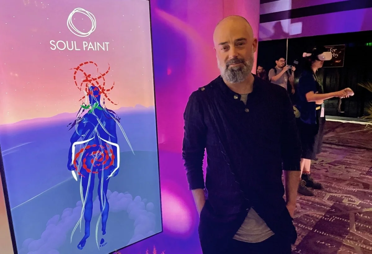 AUSTIN: Niki Smit, co-director of Soul Paint, a VR experience that let users draw their emotions on their body, poses next to the drawing of a user, at SXSW in Austin.—AFP