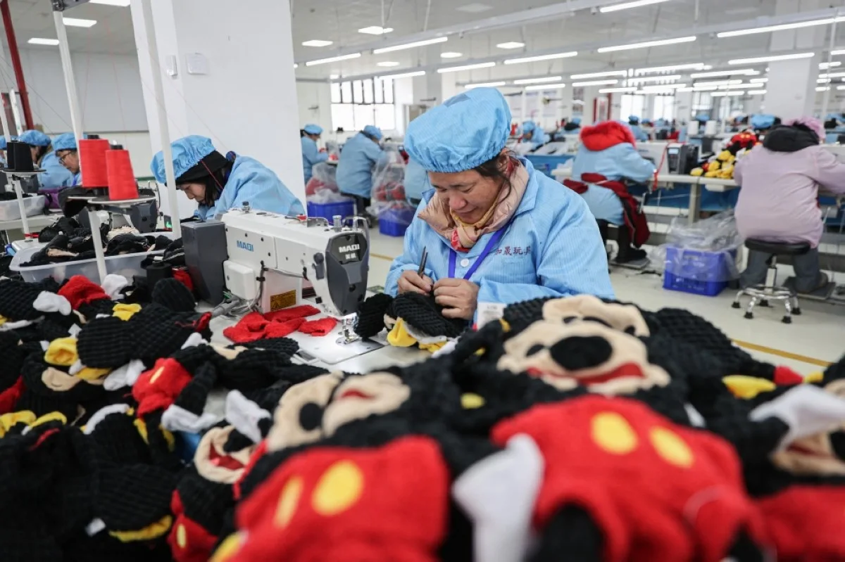 LIANYUNGANG, China: Employees work on a doll production line at a toy factory in Lianyungang, in eastern China's Jiangsu province. -- AFP