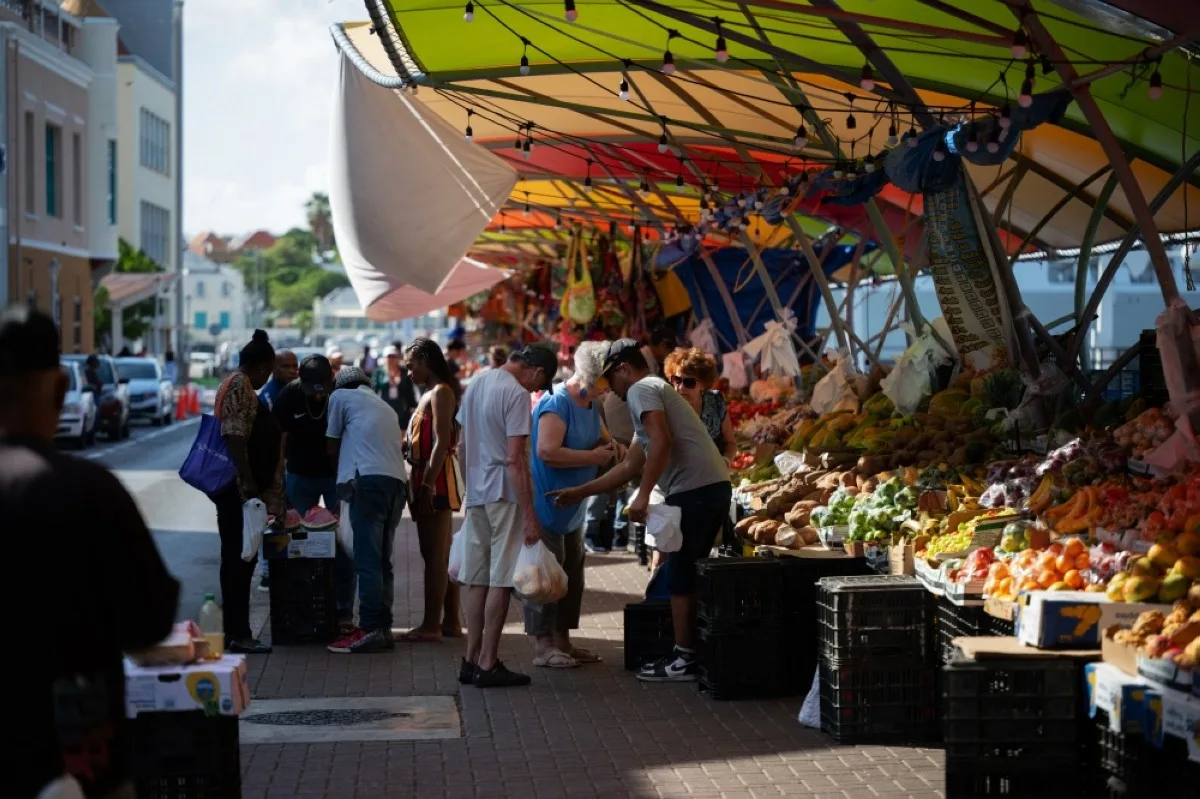 People buy vegetables and fruits at the Punda floating market on the waterfront of old town Willemstad, Curacao, in the Dutch Caribbean. – AFP