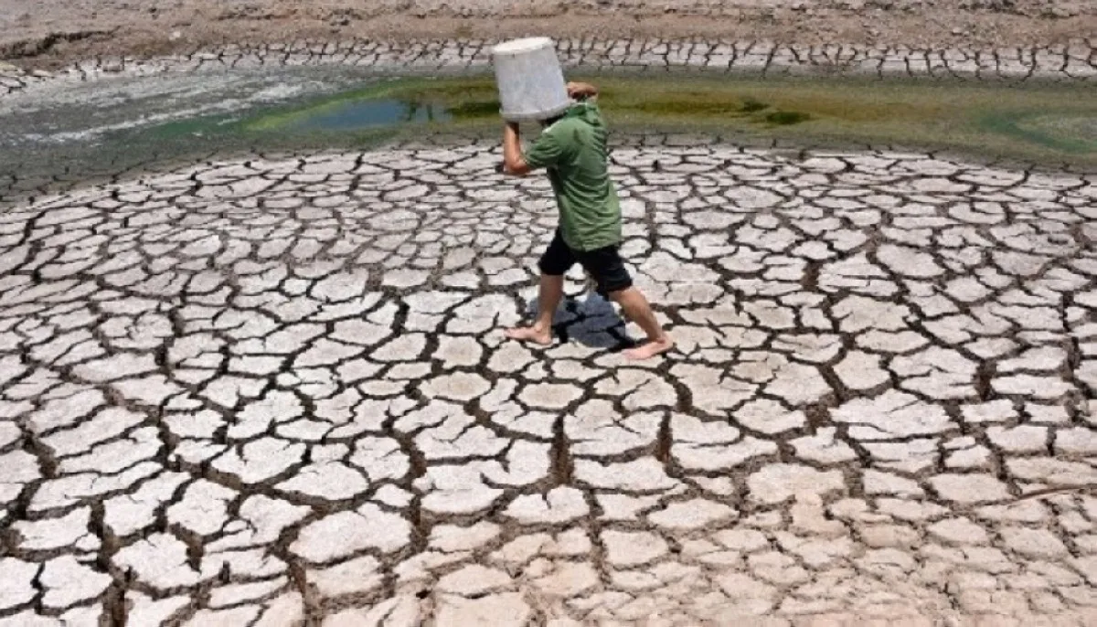A man carries a plastic bucket across the cracked bed of a dried-up pond in Vietnam's southern Ben Tre province on March 19, 2024. – AFP photo.