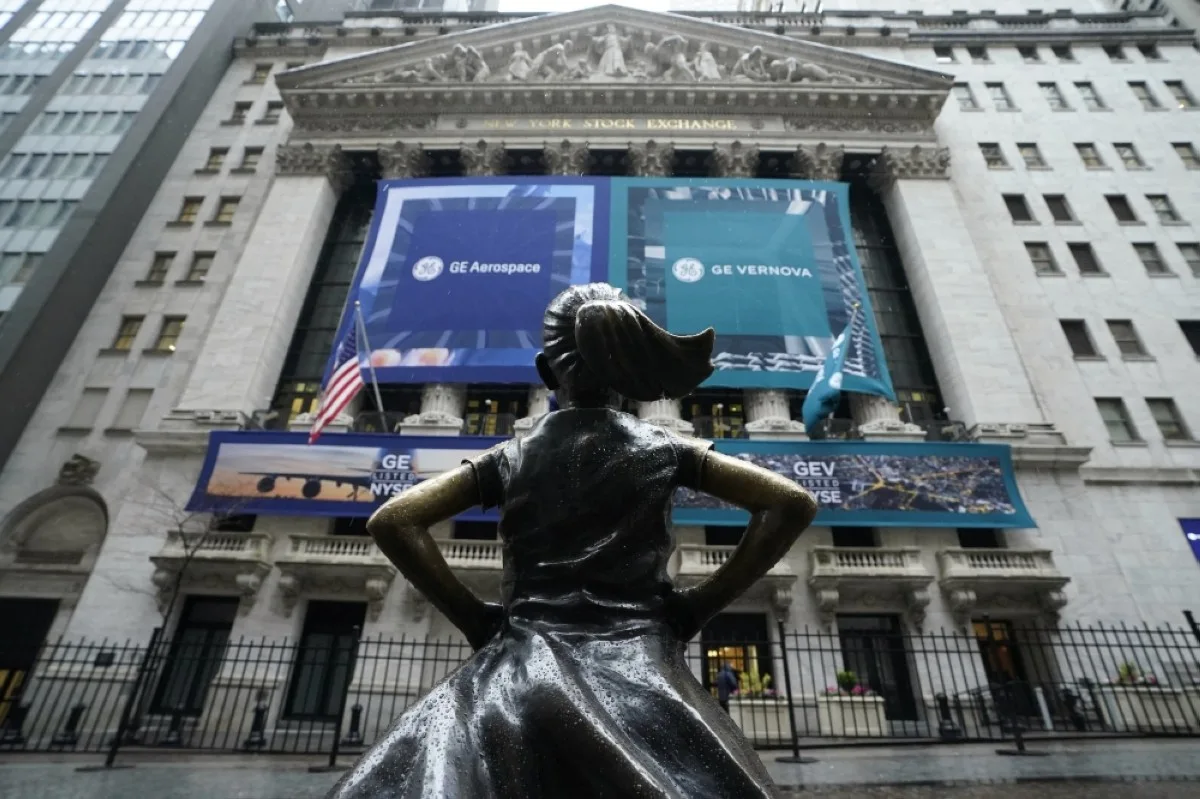 NEW YORK: The Fearless Girl bronze sculpture by Kristen Visbal stands in front of banners of the newly-formed and independent General Electric (GE) companies at the New York Stock Exchange (NYSE) on April 2, 2024. -- AFP