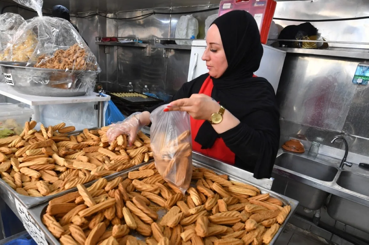 TUNIS: An employee serves pastry to a customer at a bakery in Tunis during Ramadan on March 29, 2024, amid a shortage of sugar supplies in the country. – AFP