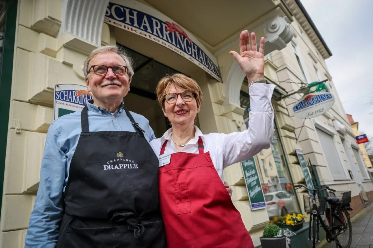 BREMEN, Germany: Juergen Scharringhausen and his wife Simone, greeting a neighbor, stand in front of their delicatessen shop in Bremen-Vegesack, northern Germany. – AFP