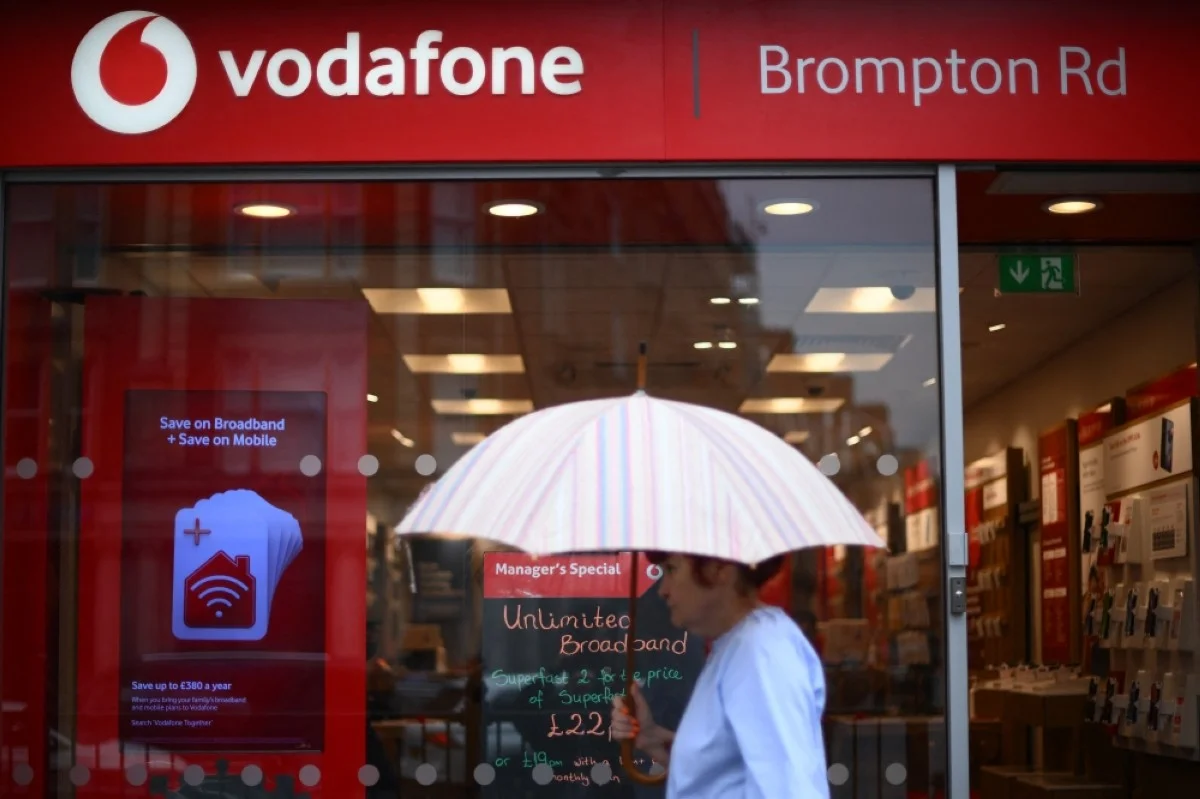 LONDON: A pedestrian passes a Vodafone store in west London.- AFP