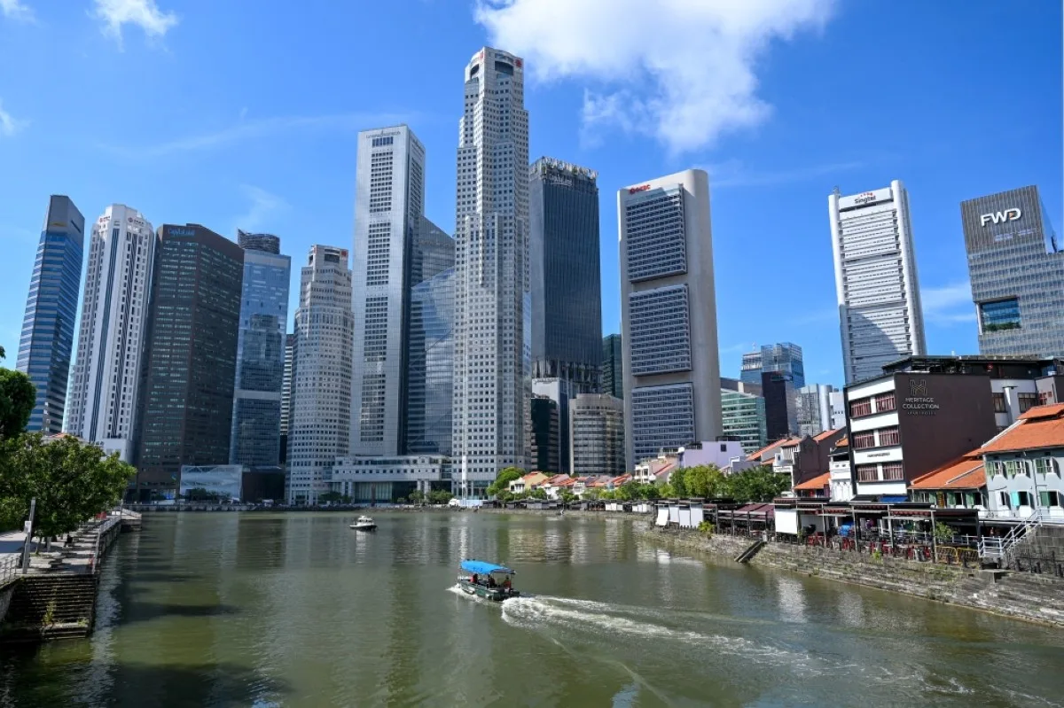 SINGAPORE: A boat cruises on the water in the central financial business district area in Singapore.- AFP
