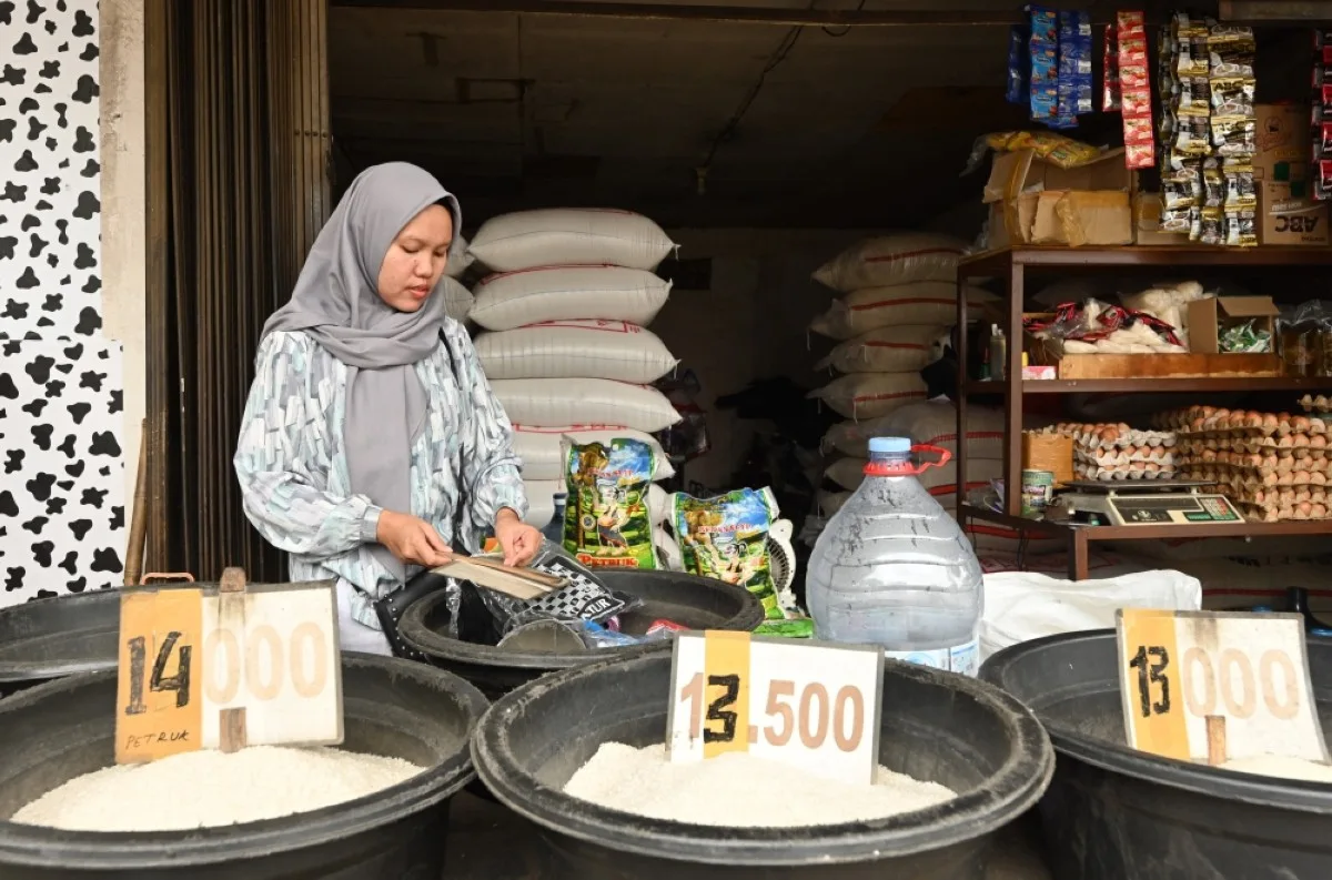 JAKARTA: A vendor waits for customers at a rice kiosk in Jakarta, amid rising prices and shortages of the staple in Indonesia. – AFP