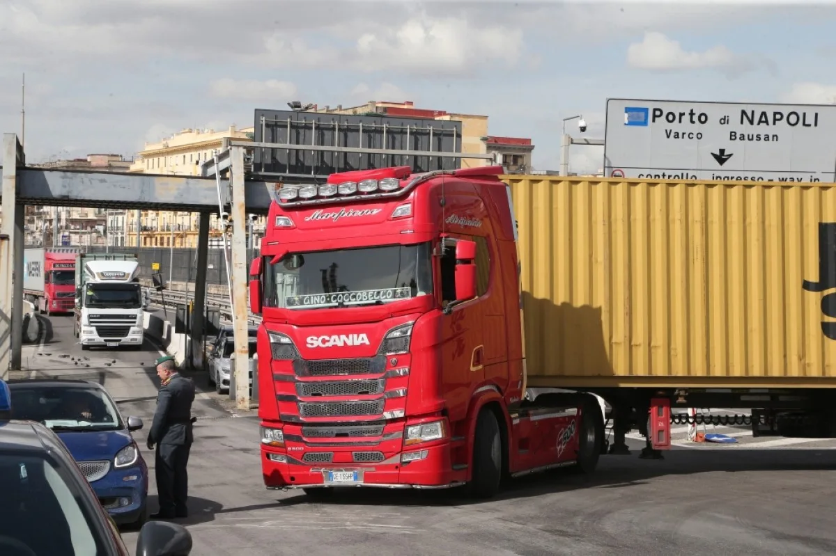 NAPLES: An officer of the Guardia di Finanza, the Italian police in charge of financial crime and smuggling, checks trucks transporting containers in the commercial area of the port of Naples.- AFP