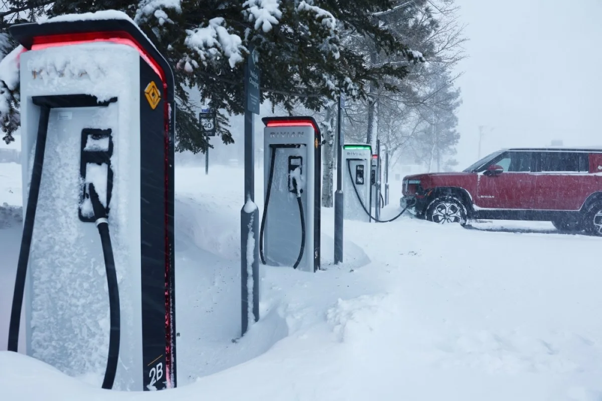 TRUCKEE: A Rivian truck recharges at a Rivian electric vehicle (EV) charging station during a snowstorm in Truckee, California. – AFP