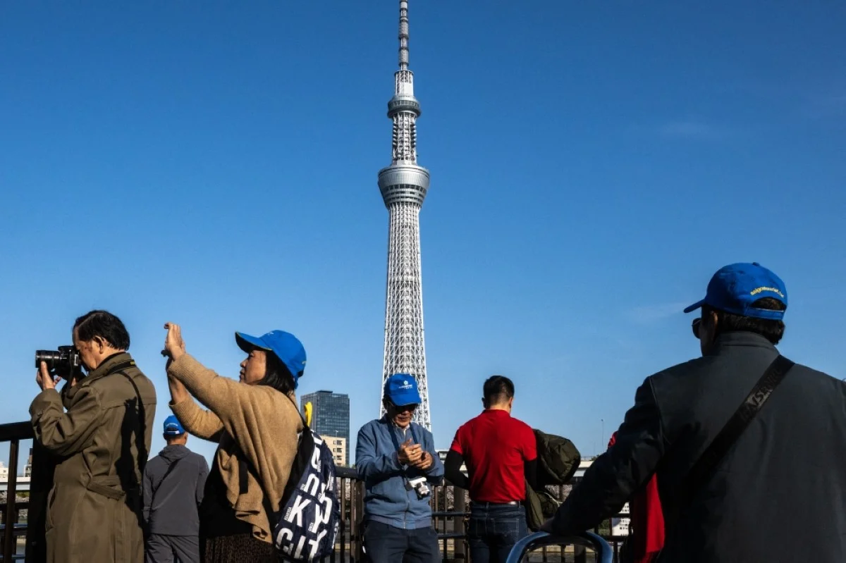 TOKYO: A group of tourists take pictures with the background of the landmark Tokyo Skytree at Sumida Park, near the famous tourism spot of Asakusa district in Tokyo. ChatGPT creator OpenAI opened a new office in Tokyo on Monday, the first Asian outpost for the groundbreaking tech company as it aims to ramp up its global expansion. –AFP