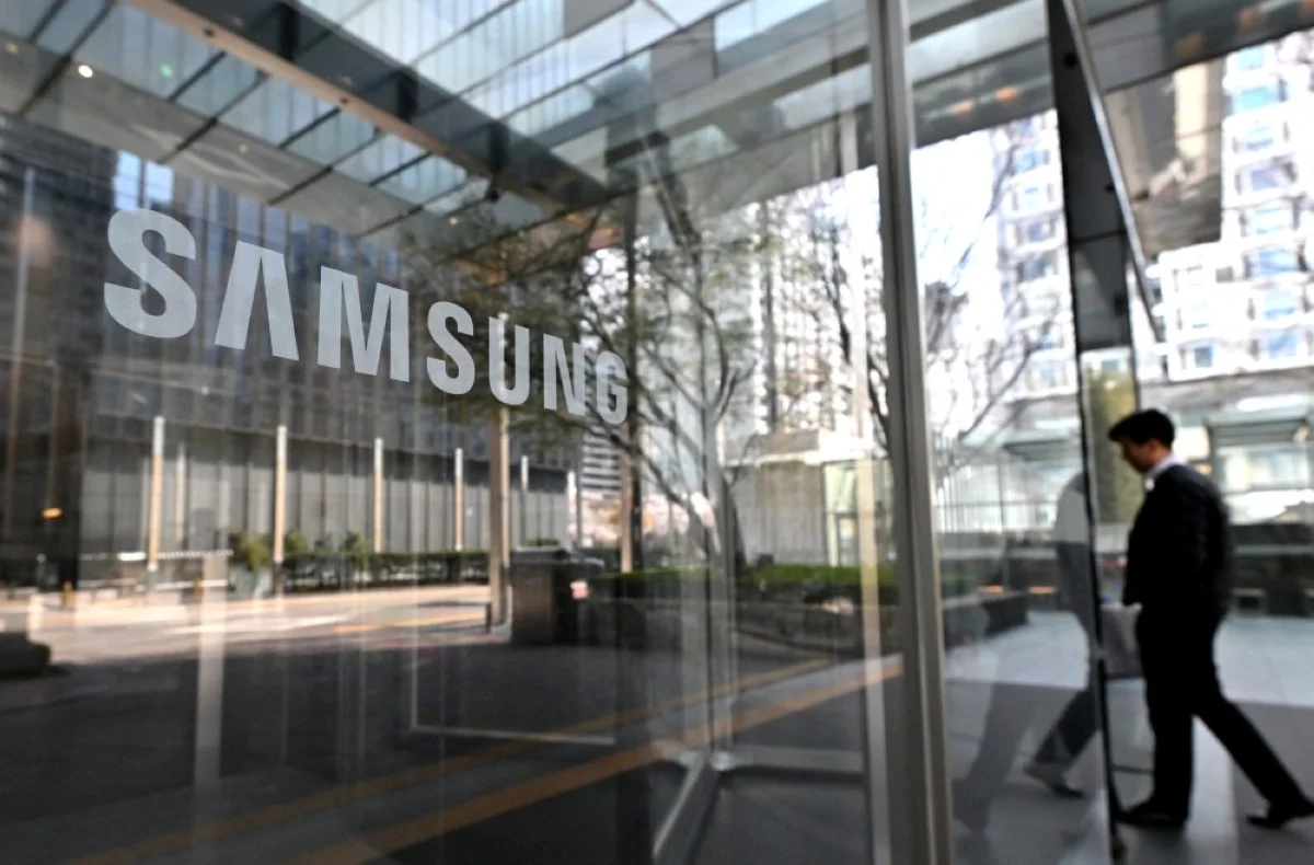 SEOUL: A man walks past the Samsung logo displayed on a glass door at the company’s Seocho building in Seoul. - AFP