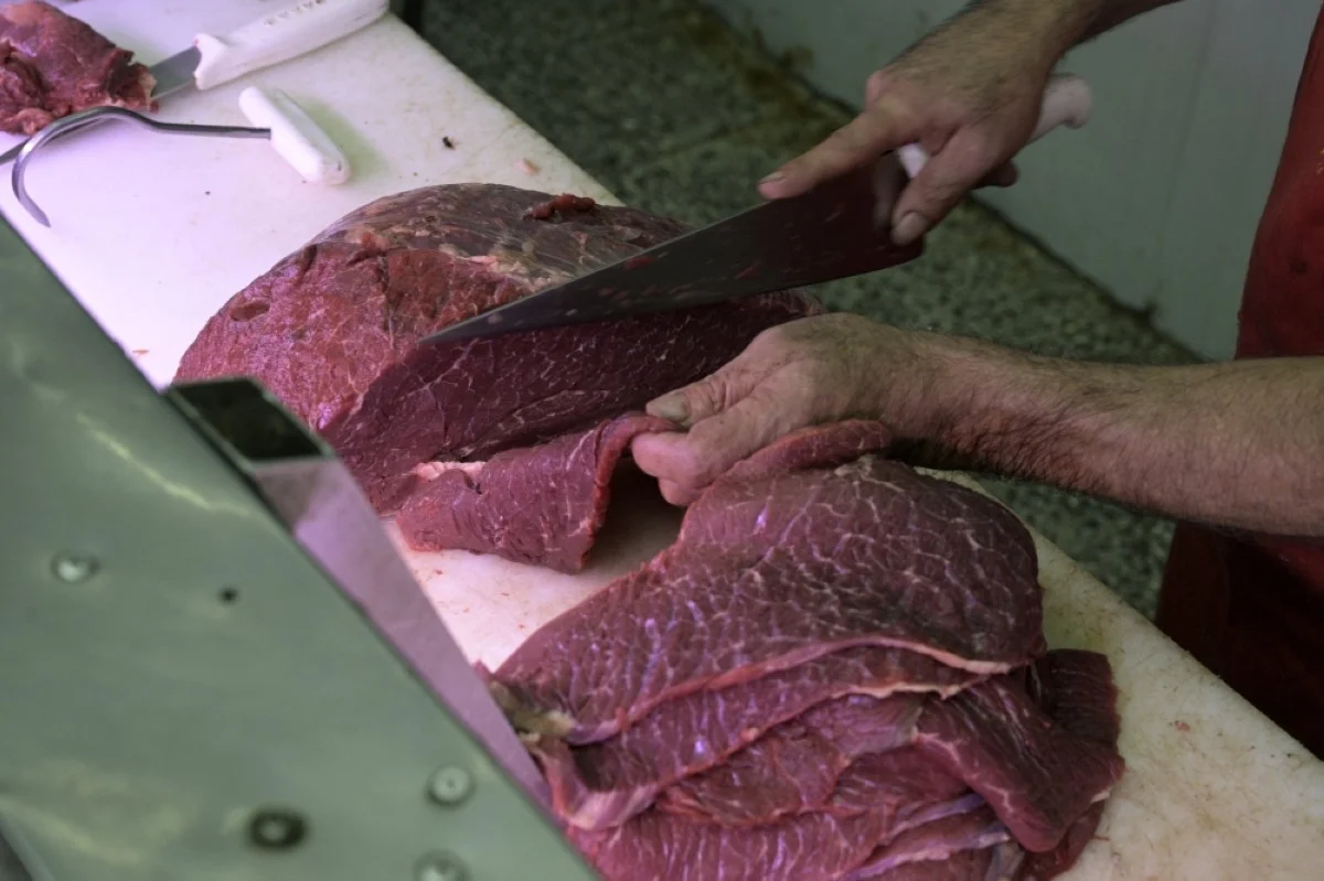 BUENOS AIRES: A butcher cuts beef for ‘milanesas’ (breaded filet) at a shot in the Central Market of Buenos Aires.- AFP