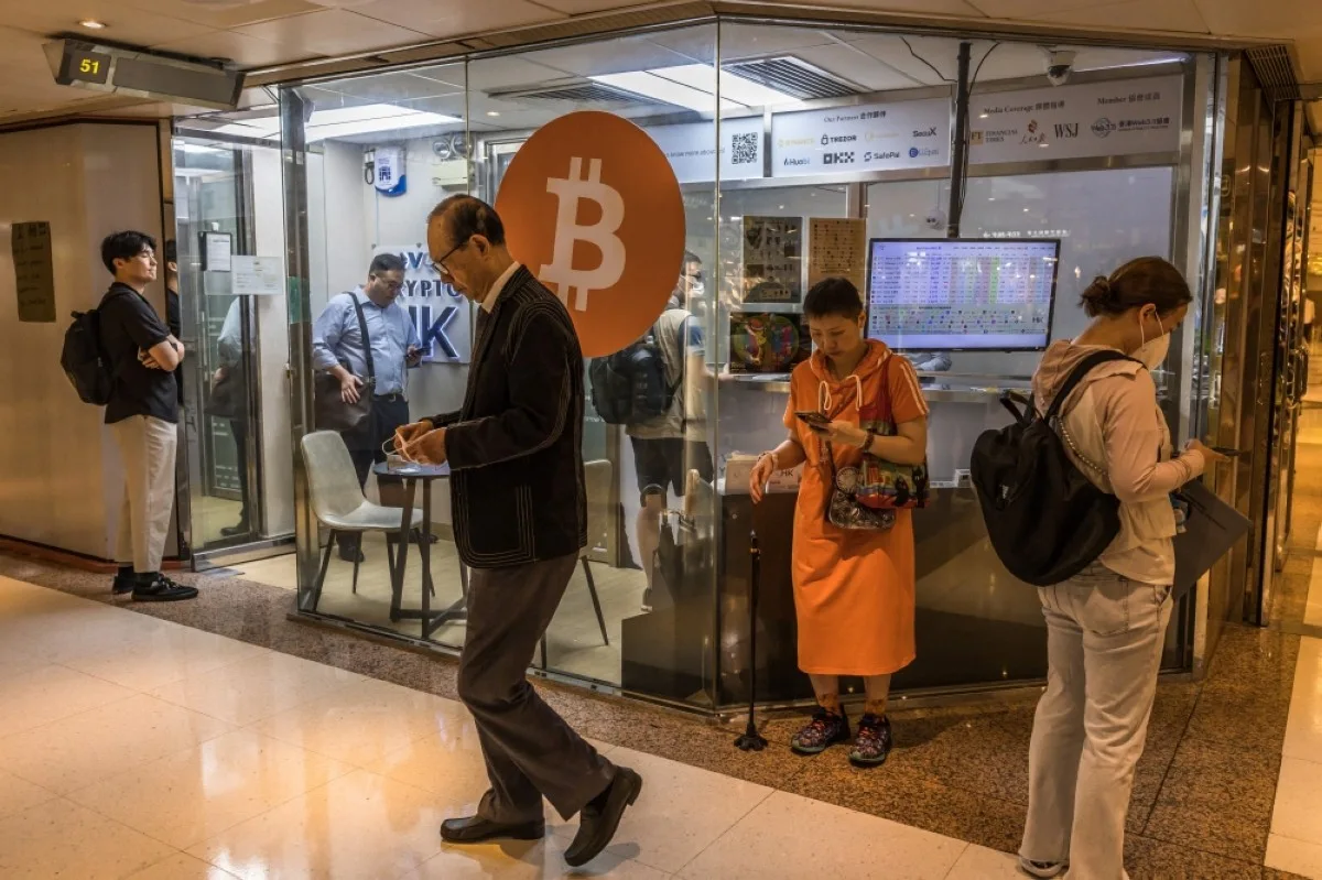 HONG KONG: People wait in a queue at a cryptocurrency exchange in Hong Kong. - AFP