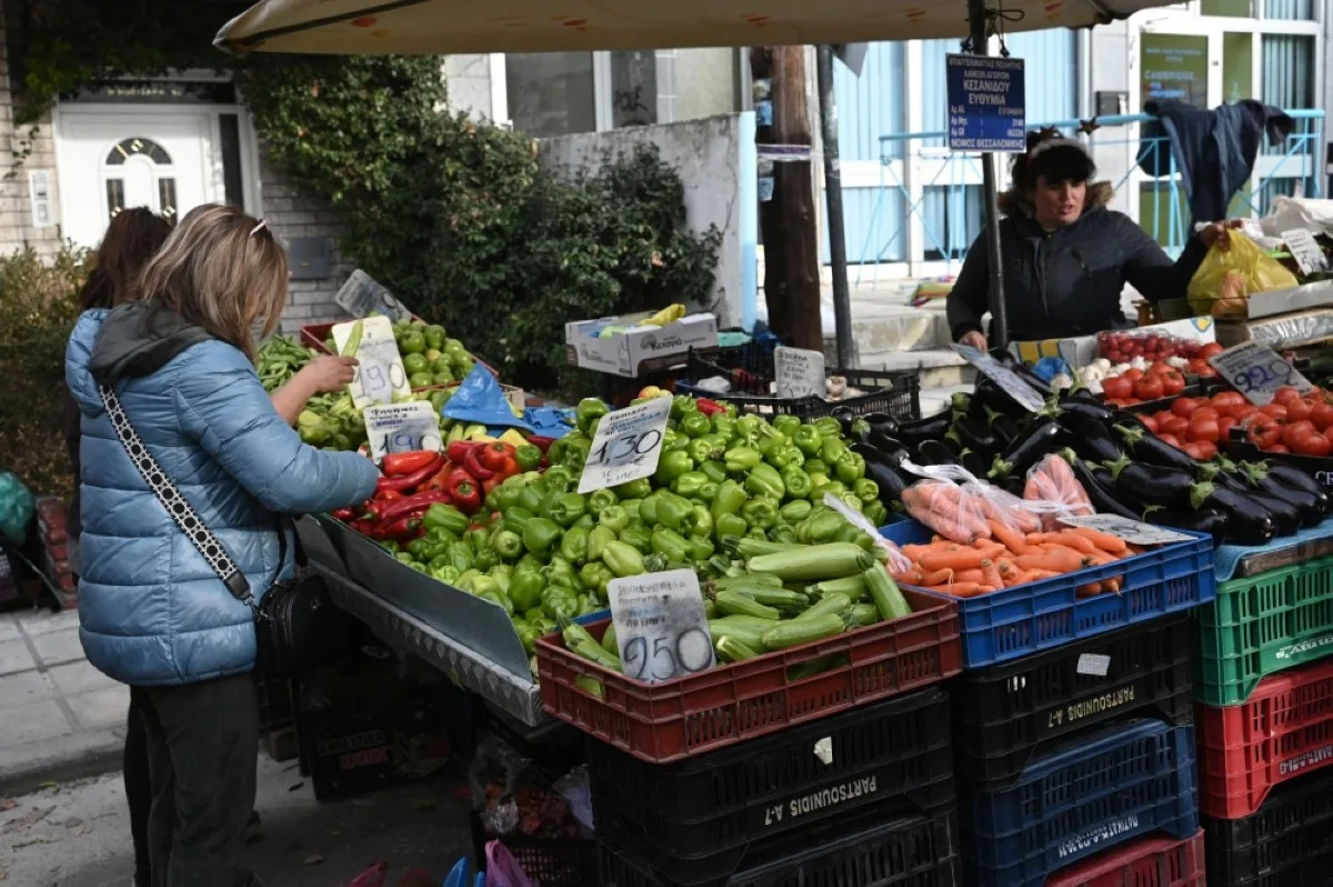 THESSALONIKI: A woman stops to buy vegetables at a stall as people shop in the local market in the northern city Thessaloniki.- AFP