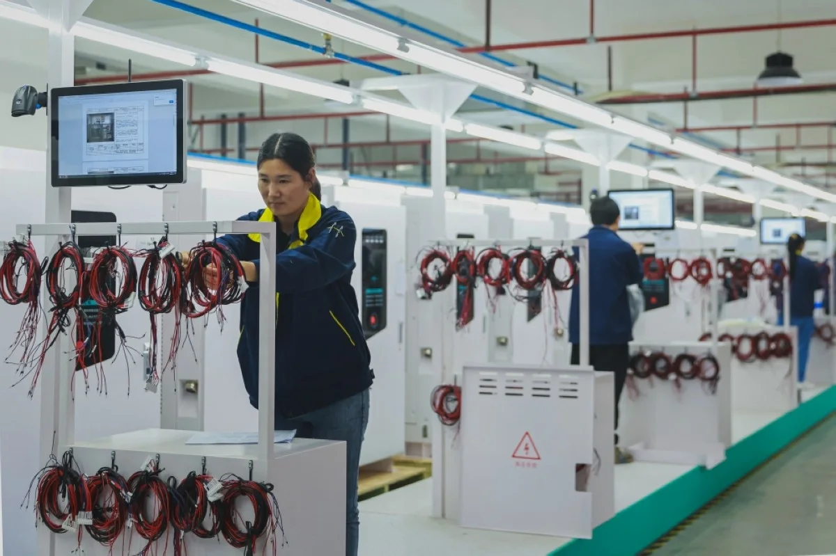 RUICHANG: Employees work at a factory that produces charging stations for electric cars in Ruichang, in central China’s Jiangxi province.- AFP