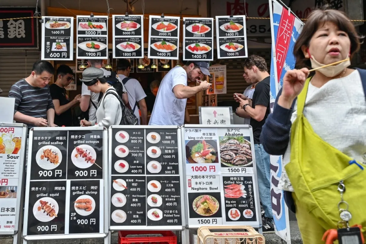 TOKYO: Visitors eat seafood during lunchtime at the popular tourist area of Tsukiji fish market in central Tokyo as the country marks the "Golden Week" holidays on April 30, 2024.-- AFP