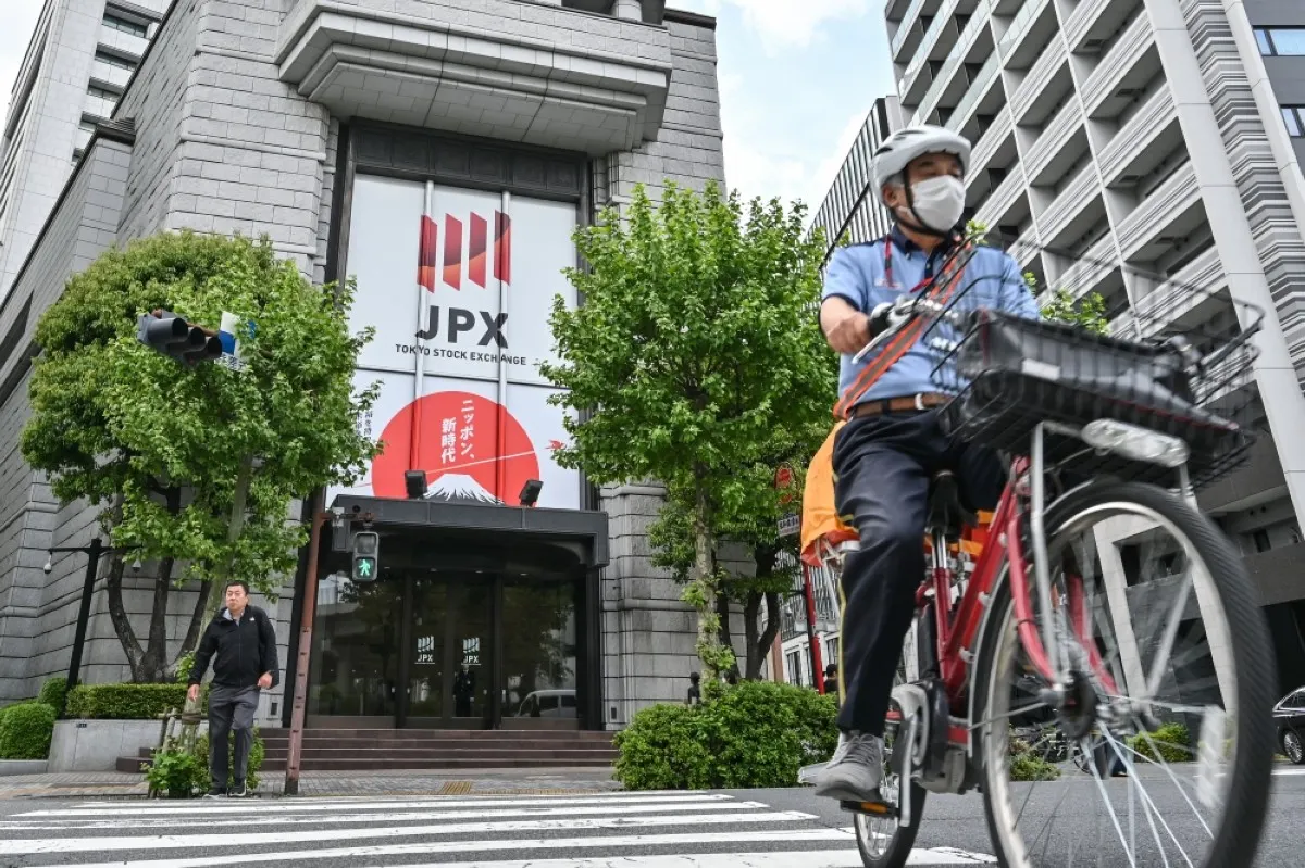 TOKYO: People crossing the street in front of the entrance to the Tokyo Stock Exchange (TSE) headquarters building in the Nihonbashi area of Tokyo.-- AFP