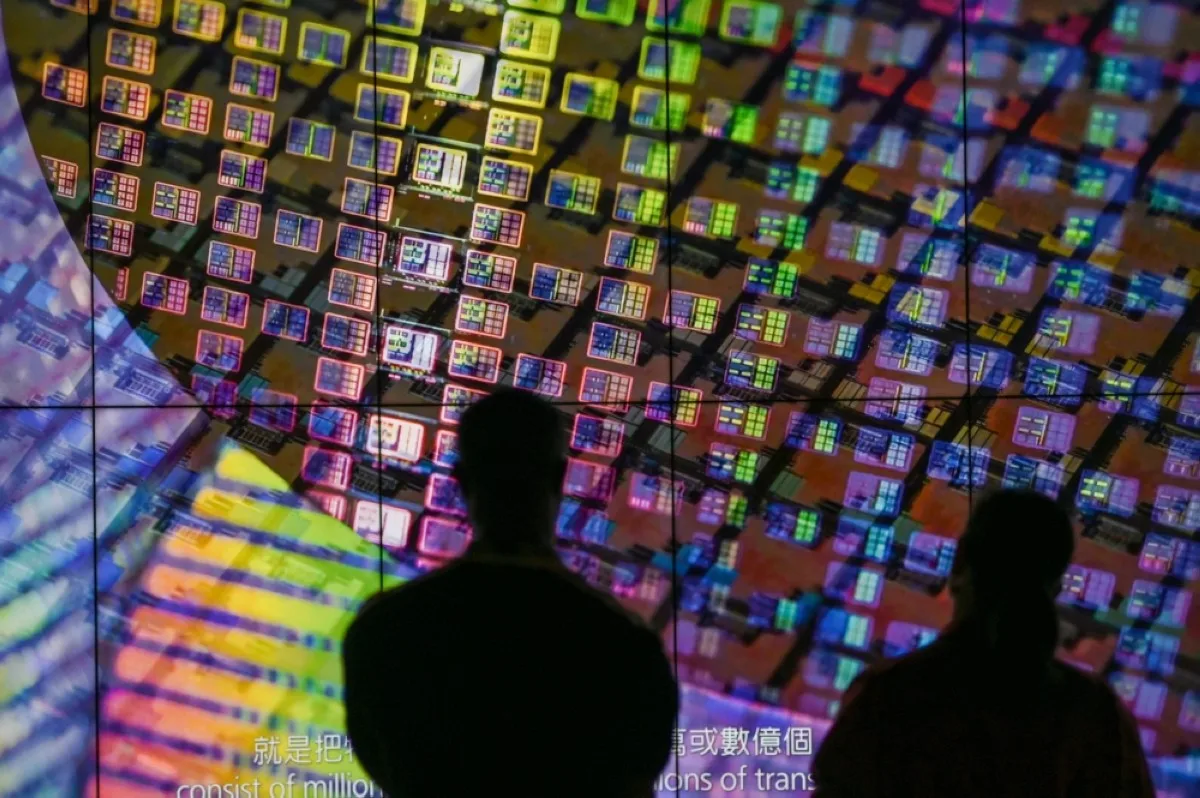 HSINCHU, Taiwan: Visitors watch a wafer shown on screens at the Taiwan Semiconductor Manufacturing Company (TSMC) Renovation Museum at the Hsinchu Science Park in Hsinchu.-- AFP