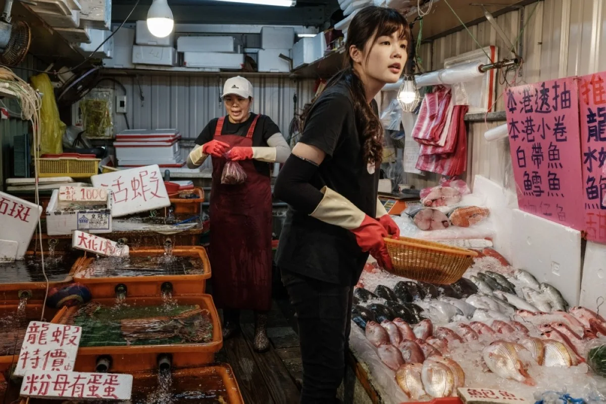 NEW TAIPEI CITY: Fish vendors listen to customers at a fish market in New Taipei City on May 18, 2024. -- AFP