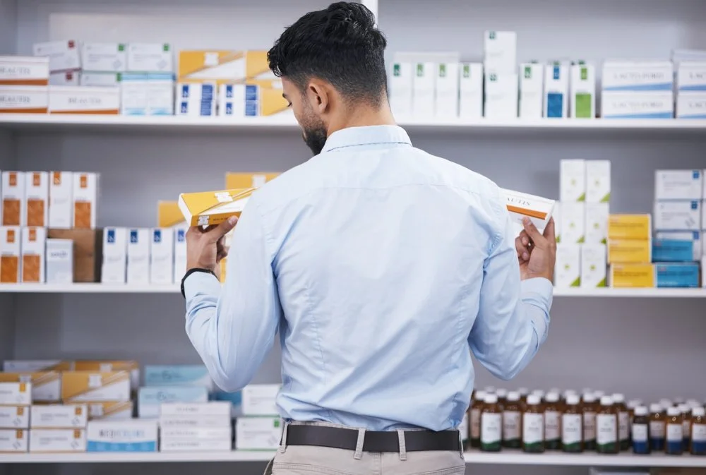 Pharmacy, medicine and man with pills choice for medication, prescription and treatment. Healthcare.