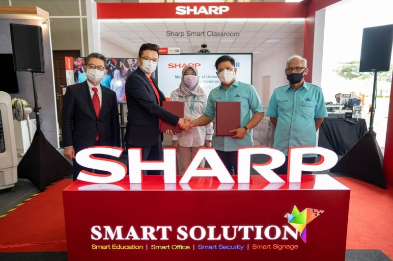 Ting (second left) exchanging the memorandum of understanding with Wan Munadi (second right). With them are (from left) Hashimoto, Maznah and Aminudin. — Picture courtesy of Sharp Electronics Malaysia