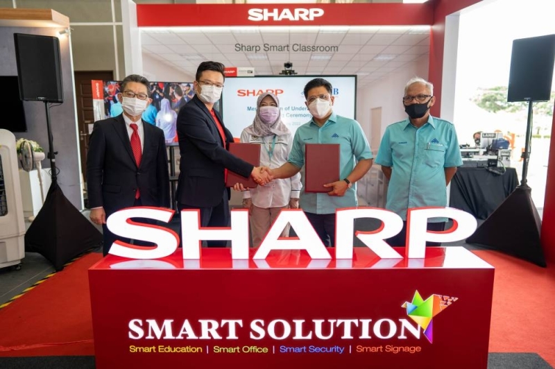 Ting (second left) exchanging the memorandum of understanding with Wan Munadi (second right). With them are (from left) Hashimoto, Maznah and Aminudin. — Picture courtesy of Sharp Electronics Malaysia Ting (second left) exchanging the memorandum of understanding with Wan Munadi (second right). With them are (from left) Hashimoto, Maznah and Aminudin. — Picture courtesy of Sharp Electronics Malaysia