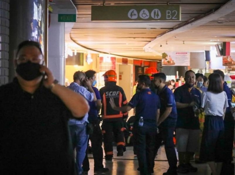 Singapore police and firefighters seen at the second basement level of VivoCity mall, where a fire led to workers from about a dozen shops and food stalls being evacuated June 7, 2022. ¬— TODAY pic