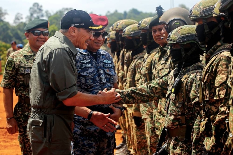 Senior Defence Minister Datuk Seri Hishammuddin Hussein shakes hands with members of the Malaysian Armed Forces at the 2022 Firepower Exercise at the Syed Sirajuddin Camp Target Range, Gemas, June 21, 2022. Also present was the Commander of the Armed Forces General Tan Sri Affendi Buang (2nd left). — Bernama pic 