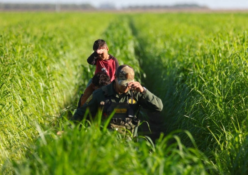 A US Border Patrol agent leads immigrants through farmland after they were captured by agents near the US-Mexico border barrier on May 21, 2022 in Yuma, Arizona. — Getty Images via AFP A US Border Patrol agent leads immigrants through farmland after they were captured by agents near the US-Mexico border barrier on May 21, 2022 in Yuma, Arizona. — Getty Images via AFP