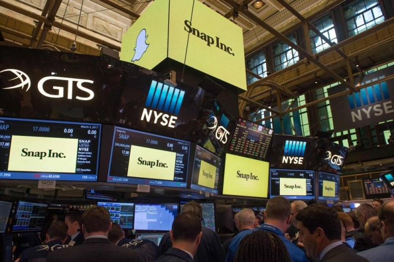 In this file photo taken on March 02, 2017, traders work on the floor during the Snap Inc. IPO at the New York Stock Exchange in New York. - Snap shares sank more than 30 percent early on July 22, 2022, following disappointing results. — AFP pic