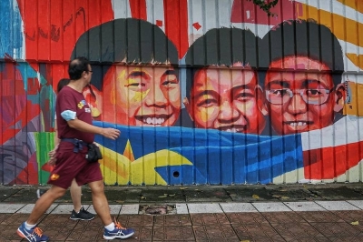 With ex-Cambodian refugee parents and siblings all Malaysians now, Pahang-born woman wins chance to continue bid for citizenship  People walk past a mural in Kuala Lumpur January 1, 2022. Having previously failed at both the High Court and Court of Appeal, Azimah had sought to appeal to the Federal Court. — Picture by Ahmad Zamzahuri
