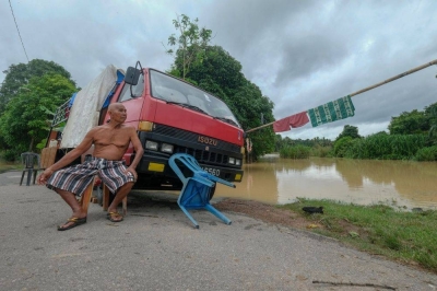 Melaka flood evacuees up to 250 A man looks at as water levels continue to rise in Kampung Belimbing Dalam, near Durian Tunggal, Alor Gajah January 3, 2022. — Bernama pic