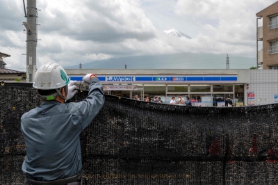 Holes poked in Mount Fuji barrier, Japan town says This file photo taken on May 21, 2024 shows a worker installing a barrier to block the sight of Japan's Mount Fuji emerging from behind a convenience store to deter badly behaved tourists, in the town of Fujikawaguchiko, Yamanashi prefecture. — AFP pic