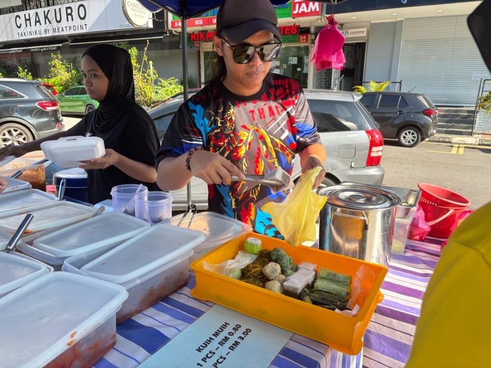 Coconut crunch hits traders — your favourite ‘nasi lemak’ and ‘kuih’ could cost you more soon Hawker Muhammad Syafiq bin Saifullizan said he will raise the price of his plain ‘nasi lemak’ from RM3 to RM3.50 next month to cope with rising costs. — Picture by Dhesegaan Bala Krishnan