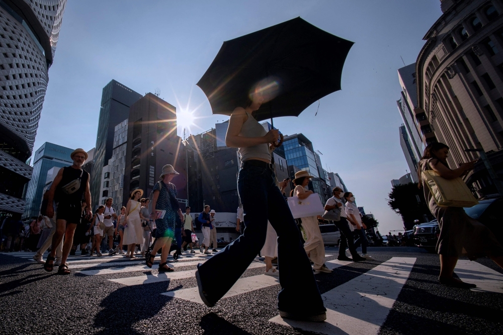 With temperatures soaring past 40.3ºC, 17 heat records broken in Japan People cross a street on a hot day in Tokyo on August 4, 2025. — AFP pic