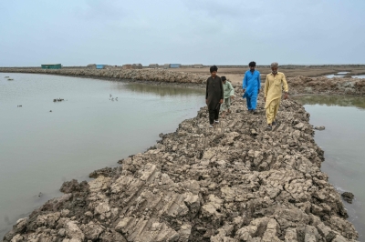What Pakistan stands to lose as the Indus delta collapses under climate pressure and water disputes In this photograph taken on June 25, 2025, Haji Karam Jat (right), a fisherman, and his family members walk along an embankment in Keti Bandar town of Thatta district near the Indus delta, in the south of Pakistan. — AFP pic