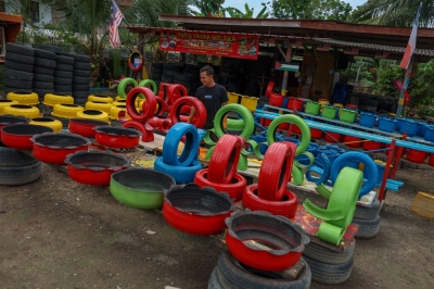 From scrap to art: Ex-lorry driver turns used tyres into thriving business Entrepreneur Muhammad Akhmal Adib, 33, inspects his tyre-based decorations drying in the sun at his workshop in Kampung Pulau near Durian Tunggal, Melaka. — Bernama pic