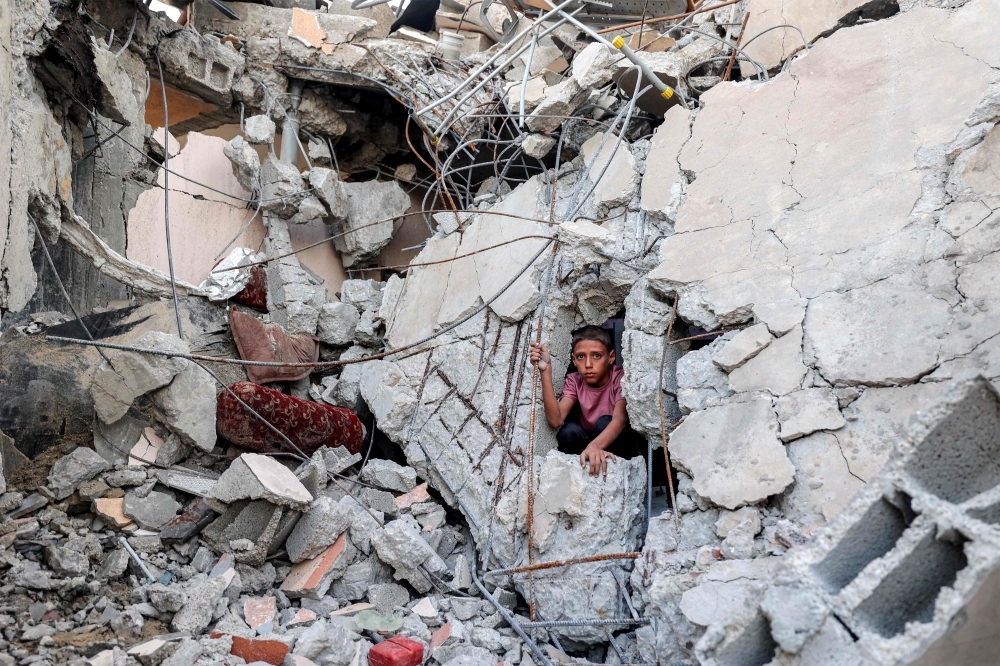 Report: US could take control of Gaza, displace all its people under Trump-backed postwar plan A boy climbs from out of the rubble of a collapsed building that was hit by bombardment in the Nuseirat camp for Palestinian refugees in the central Gaza Strip August 30, 2025. — AFP pic