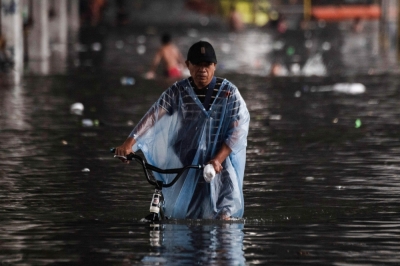 Philippine contractors allege lawmaker payoffs in flood control scandal In this photo taken on July 21, 2025, a man wades through a flooded street after heavy rains in Manila. Philippine construction firms paid off 17 lawmakers to secure government contracts, their owners claimed on September 8 at a hearing on graft in flood control projects. — AFP pic