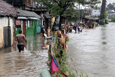 Torrential rains trigger deadly floods across Bali and Flores, leaving at least 13 dead and dozens missing Residents wade through floodwaters in their neighbourhood following heavy rainfall in Denpasar. — AFP pic