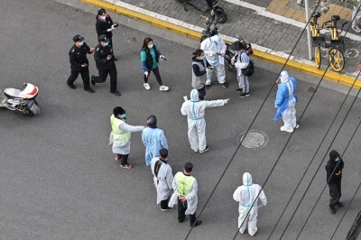 China enacts new law to fast-track health crisis response after Covid failures A health worker (centre) wearing personal protective gear gestures to residents on a street during the second stage of a Covid-19 lockdown in Jing’an district in Shanghai in this file picture dated April 1, 2022. — AFP pic